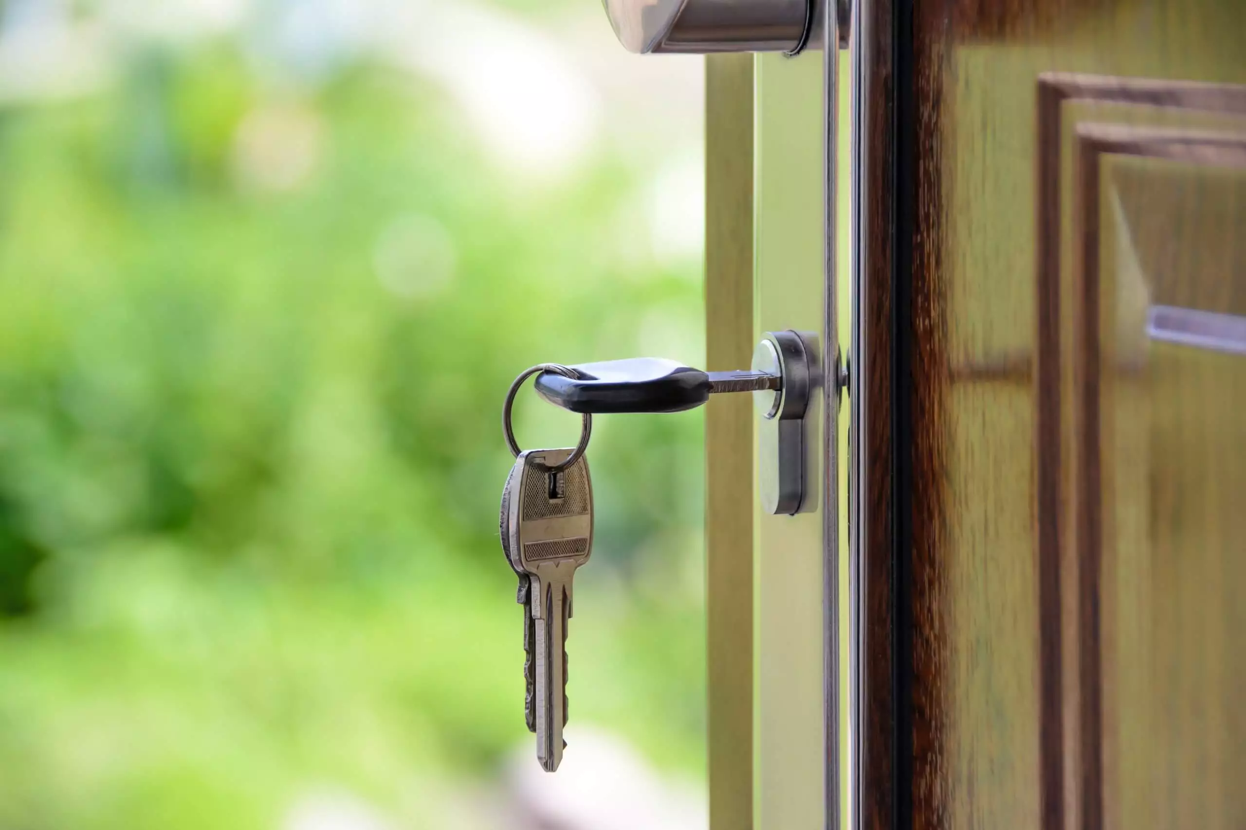 Klucze w drzwiach - Homely Estates - Biuro Nieruchomości - Zdjęcie w tle